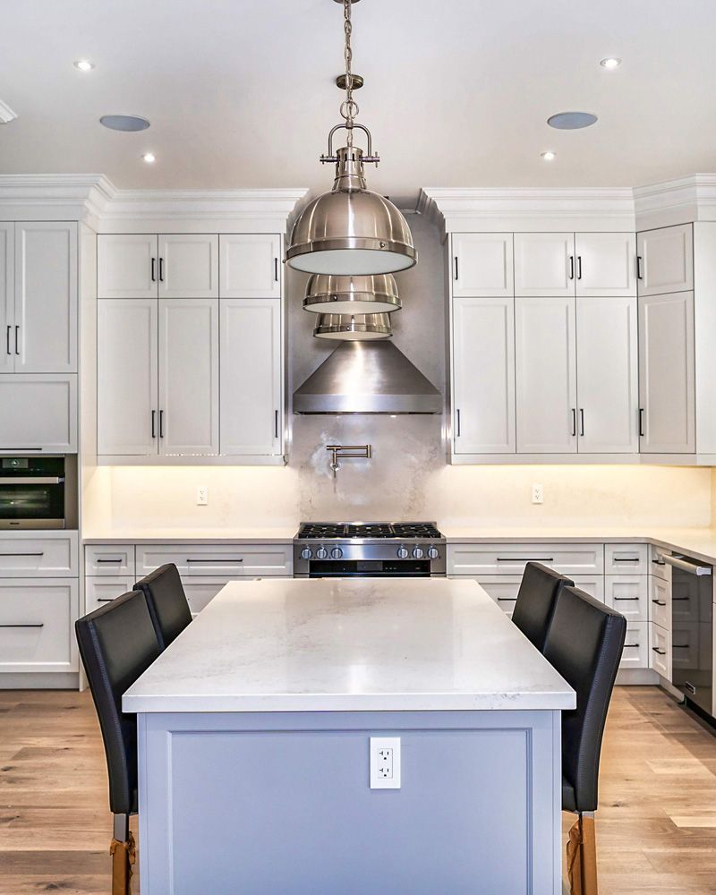 A kitchen with white cabinets and stainless steel appliances in Hazelridge Dr by Oakroots Construction