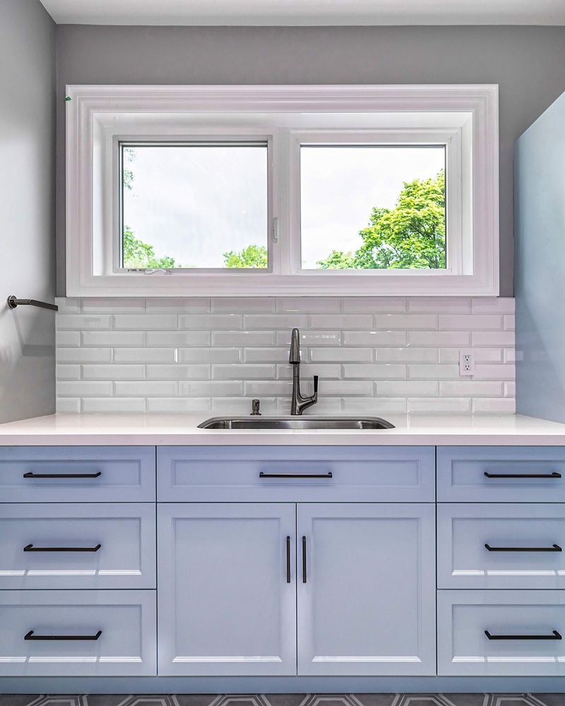 A kitchen with a sink, cabinets, drawers and a window in Hazelridge Dr by Oakroots Construction