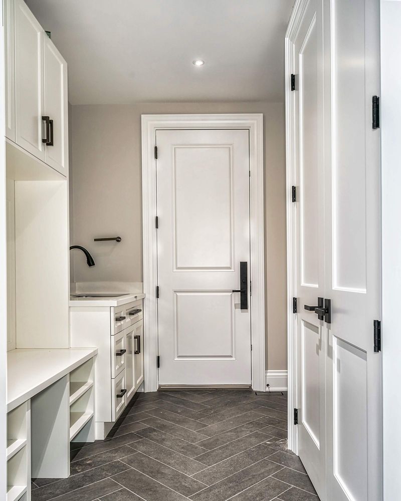 A hallway with white cabinets and a door in a house in Hazelridge Dr by Oakroots Construction