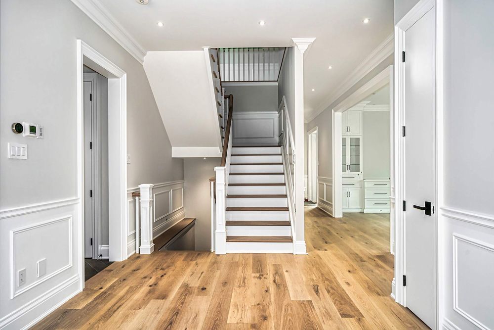 There is a staircase in the middle of the hallway in Hazelridge Dr by Oakroots Construction
