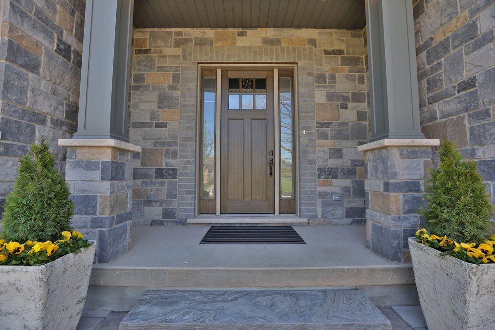 The front door of a house with a stone wall and steps