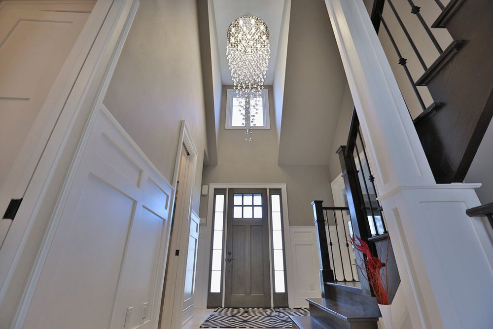 A hallway with stairs and a chandelier hanging from the ceiling