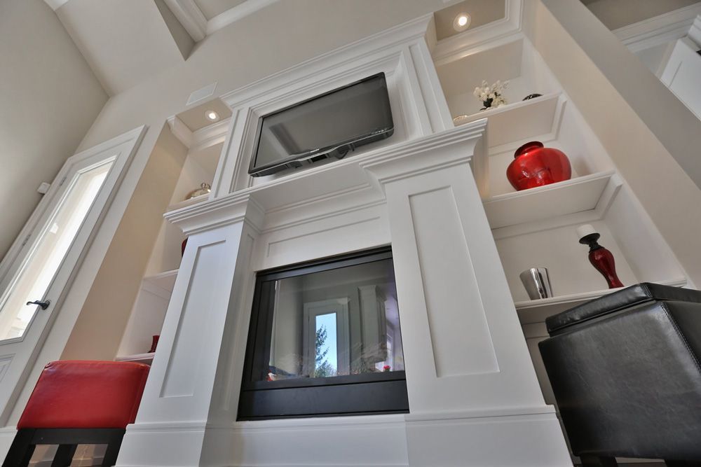 A living room with a fireplace and a television on the mantle.