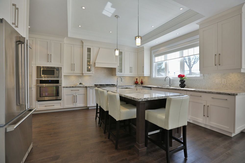A kitchen with white cabinets and stainless steel appliances