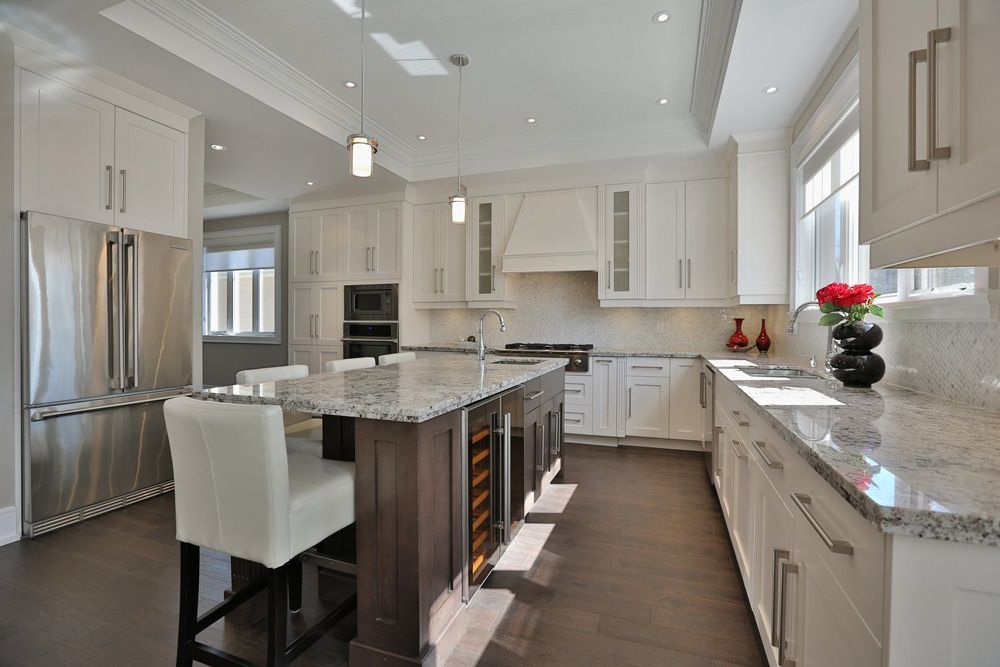 A kitchen with white cabinets and stainless steel appliances