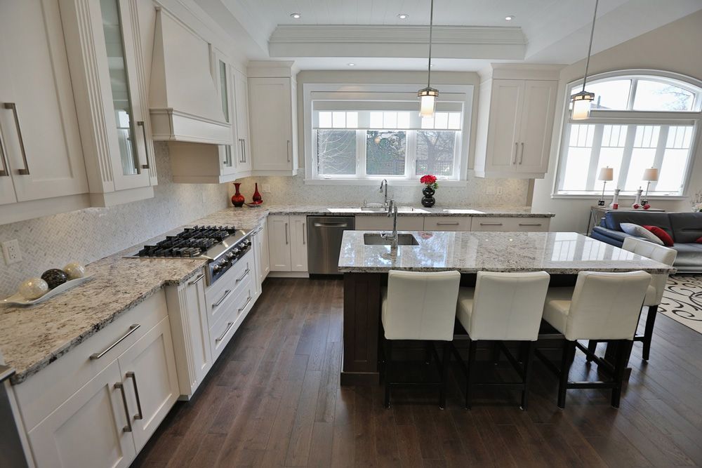 A kitchen with white cabinets and granite counter tops