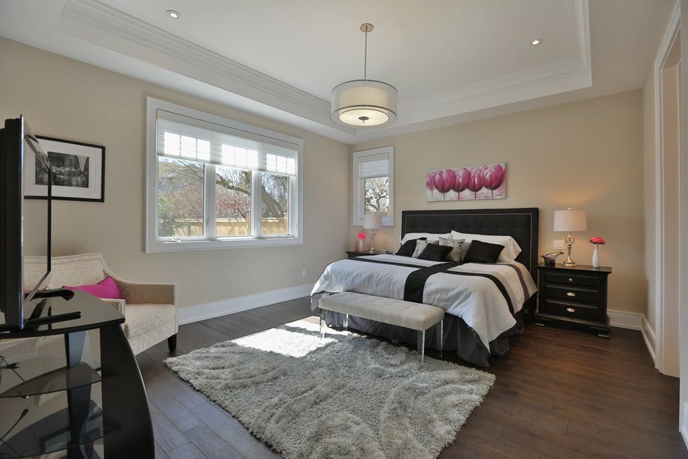 A bedroom with a large bed , a bench and a television.