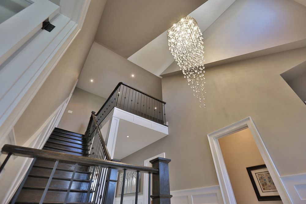 A staircase in a house with a chandelier hanging from the ceiling.