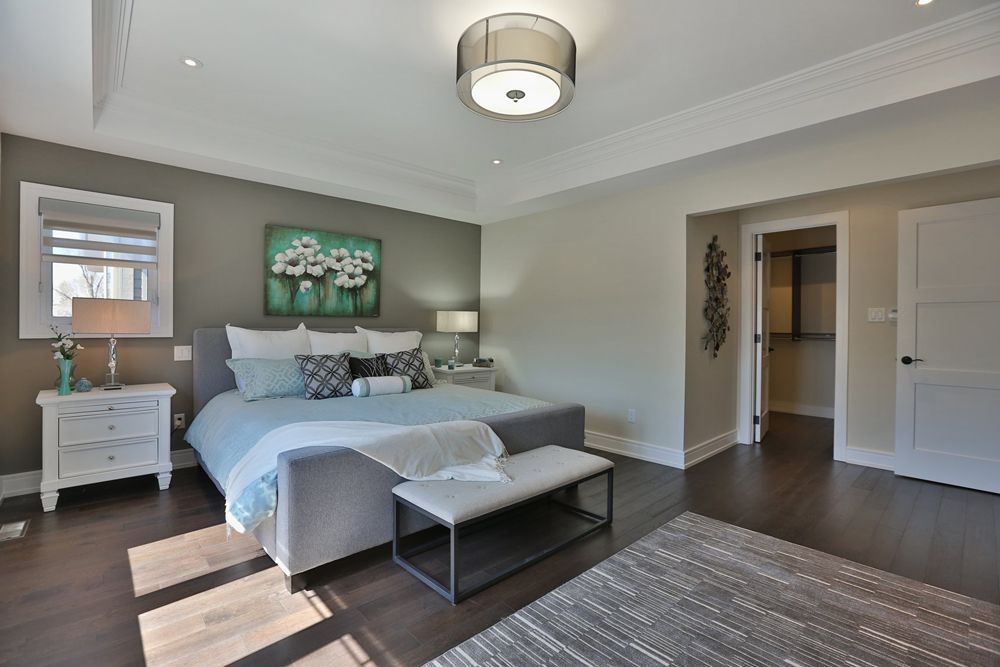 A bedroom with a large bed , nightstand , and bench.