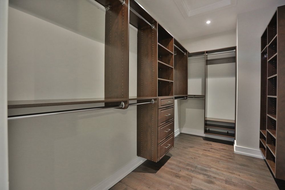 A walk in closet with lots of shelves and drawers.