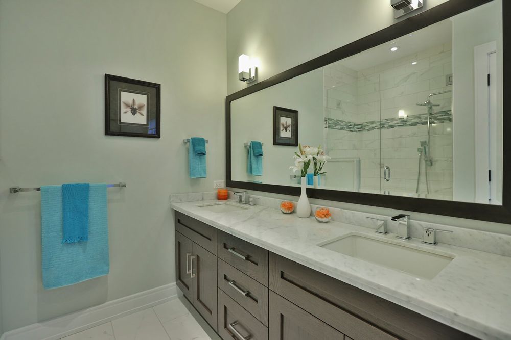 A bathroom with two sinks and a large mirror.