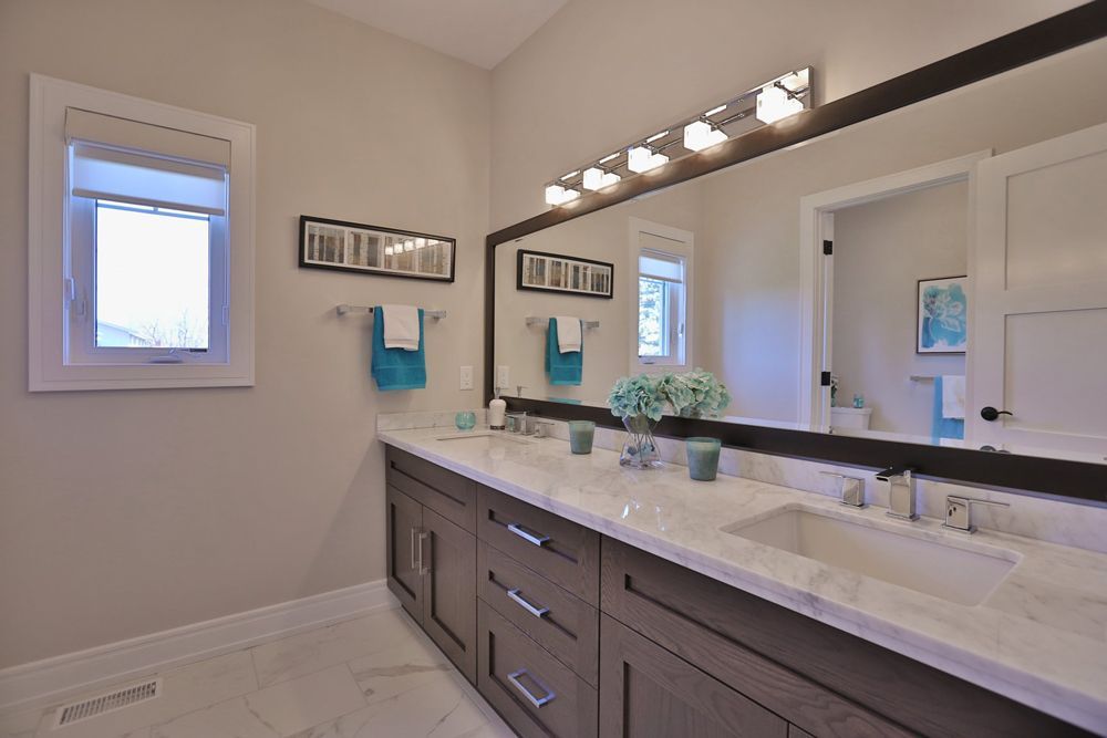 A bathroom with two sinks and a large mirror.