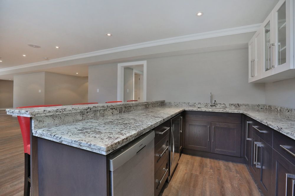 A kitchen with granite counter tops and stainless steel appliances.