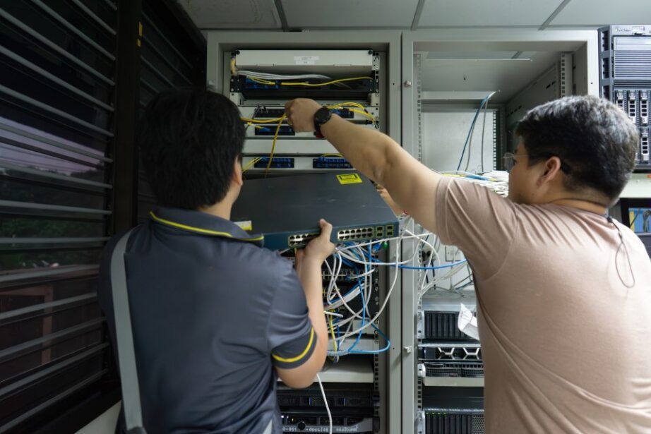 Two Technicians Working on Network Hardware in A Server Room — Pacific Telephone & Data in Hunter Valley, NSW