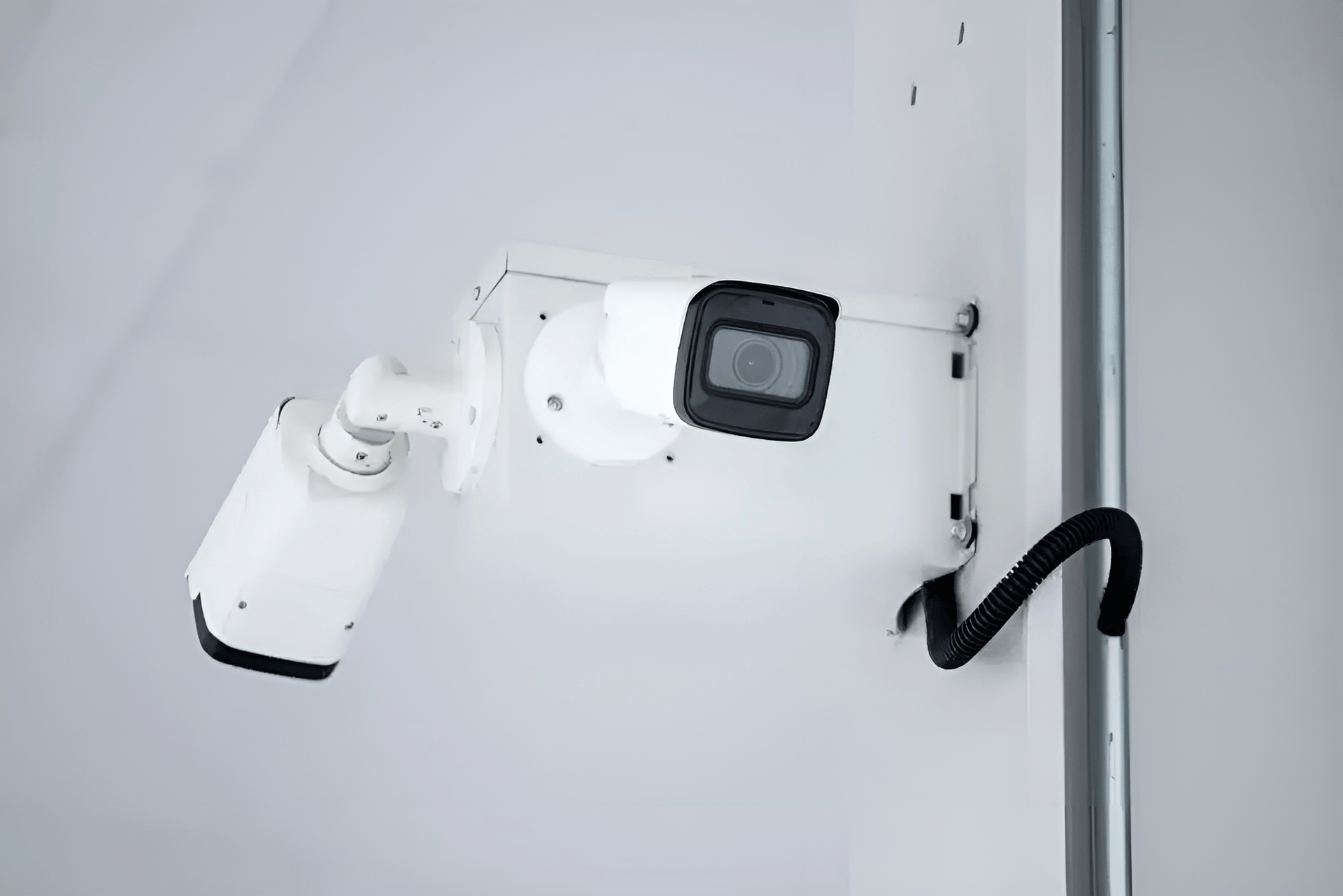 Two White Security Cameras Mounted on A Wall — Pacific Telephone & Data In Cardiff, NSW