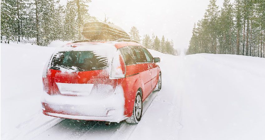 Mini Van Driving on snow covered road in the woods