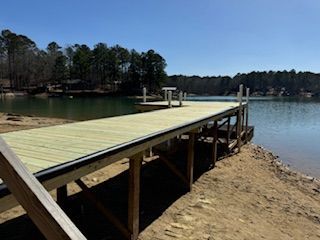 A wooden dock is sitting on the shore of a lake.