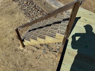 A shadow of a person is cast on a wooden staircase.