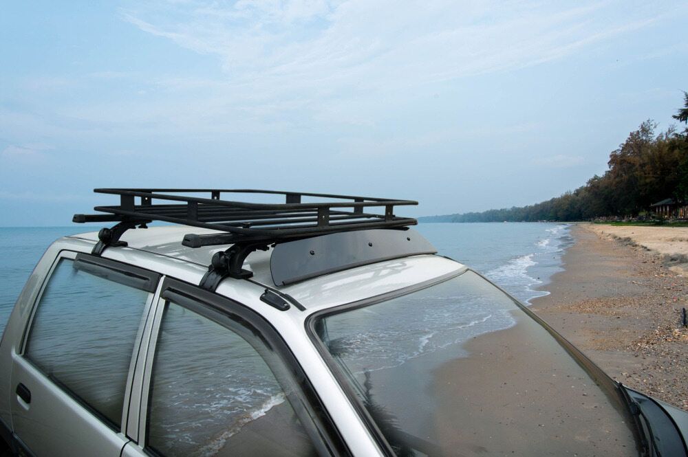 A Car With A Roof Rack Is Parked On The Beach — Superior Machinery Maintenance In Ryan, QLD