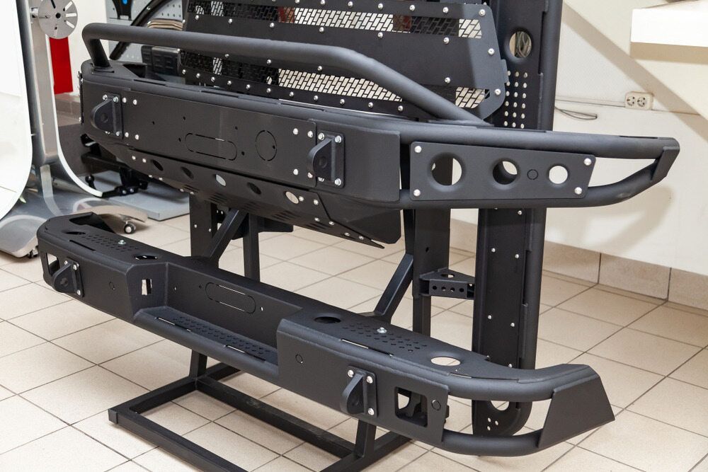 A Black Bumper Is Sitting On Top Of A Tiled Floor — Superior Machinery Maintenance In Ryan, QLD