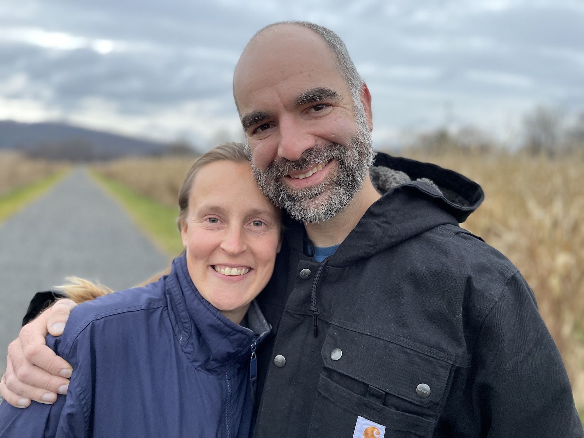 A man and a woman are standing next to each other on a road.
