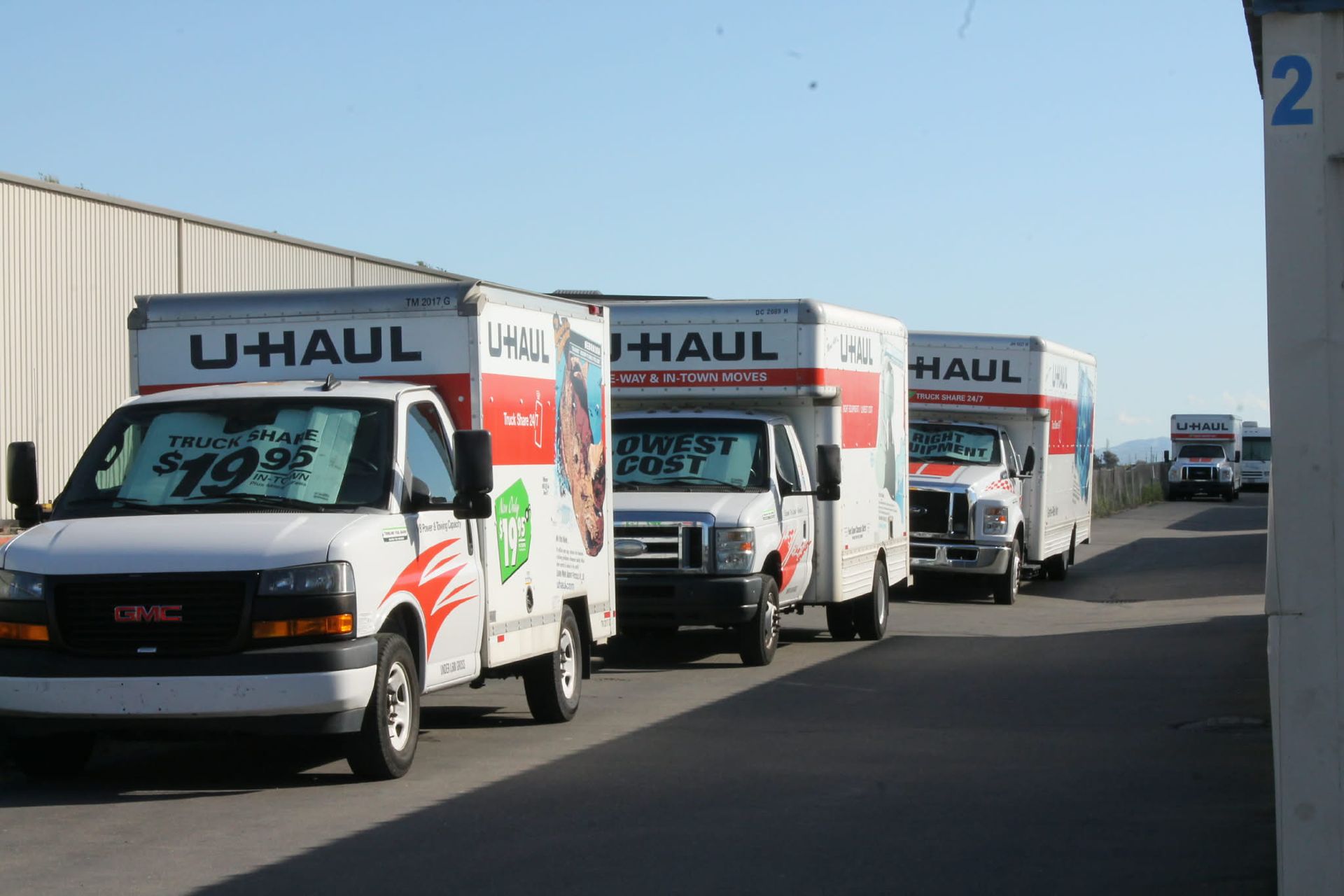 Moving truck filled with packed boxes and furniture, parked in front of a house.