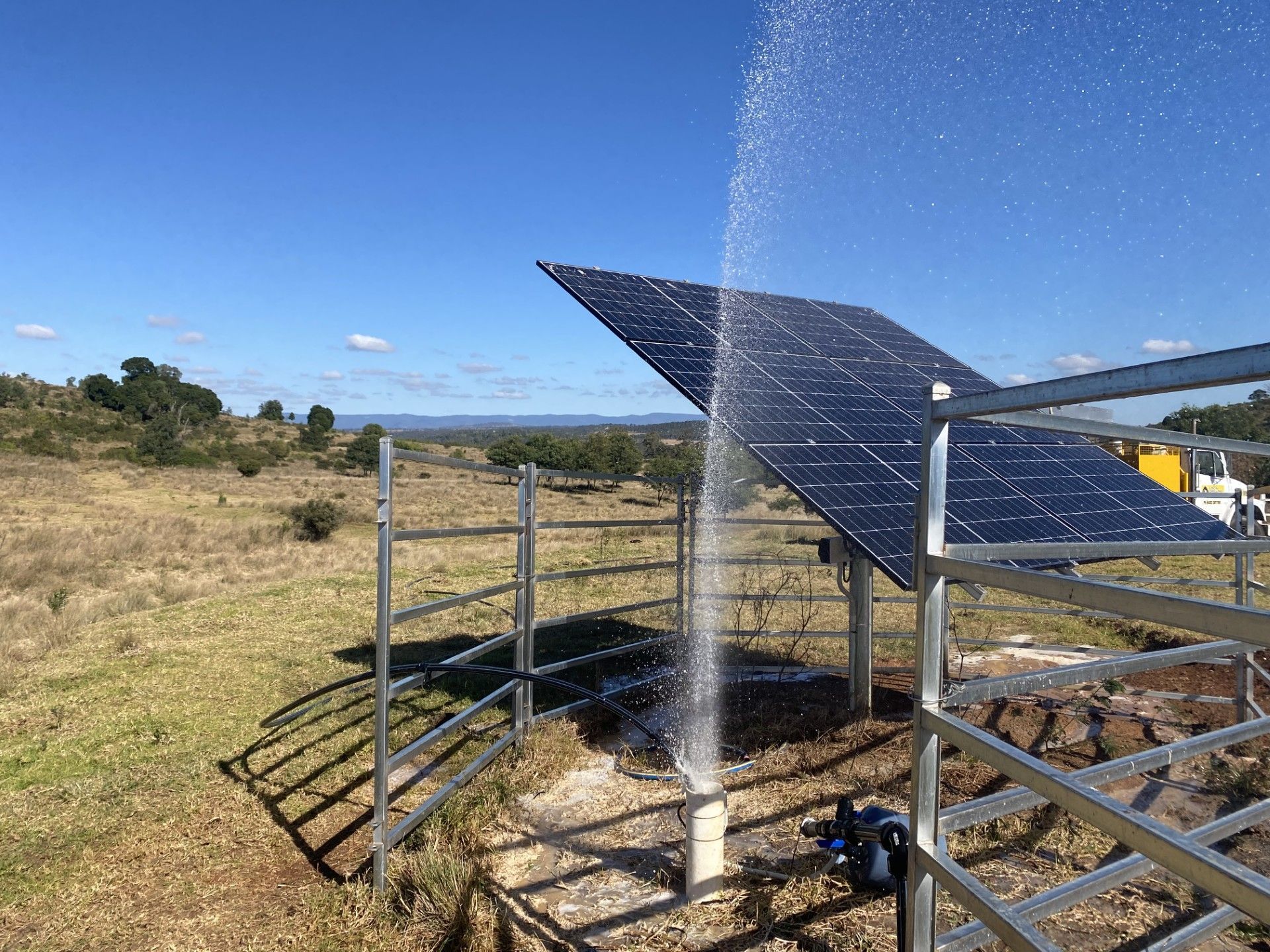 Solar Panel Spraying Water in a Field, With a Fence and Pump — Local Drilling Services In Kilcoy, QLD