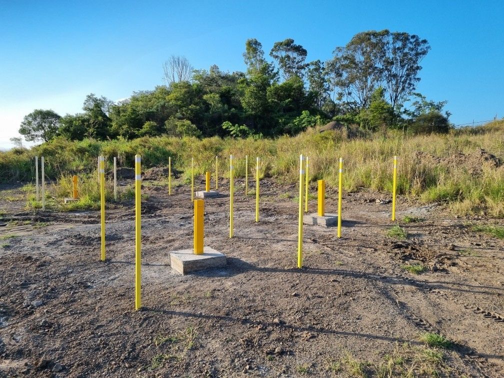 Yellow Poles Marking Locations on a Dirt Lot — Local Drilling Services In South Burnett, QLD