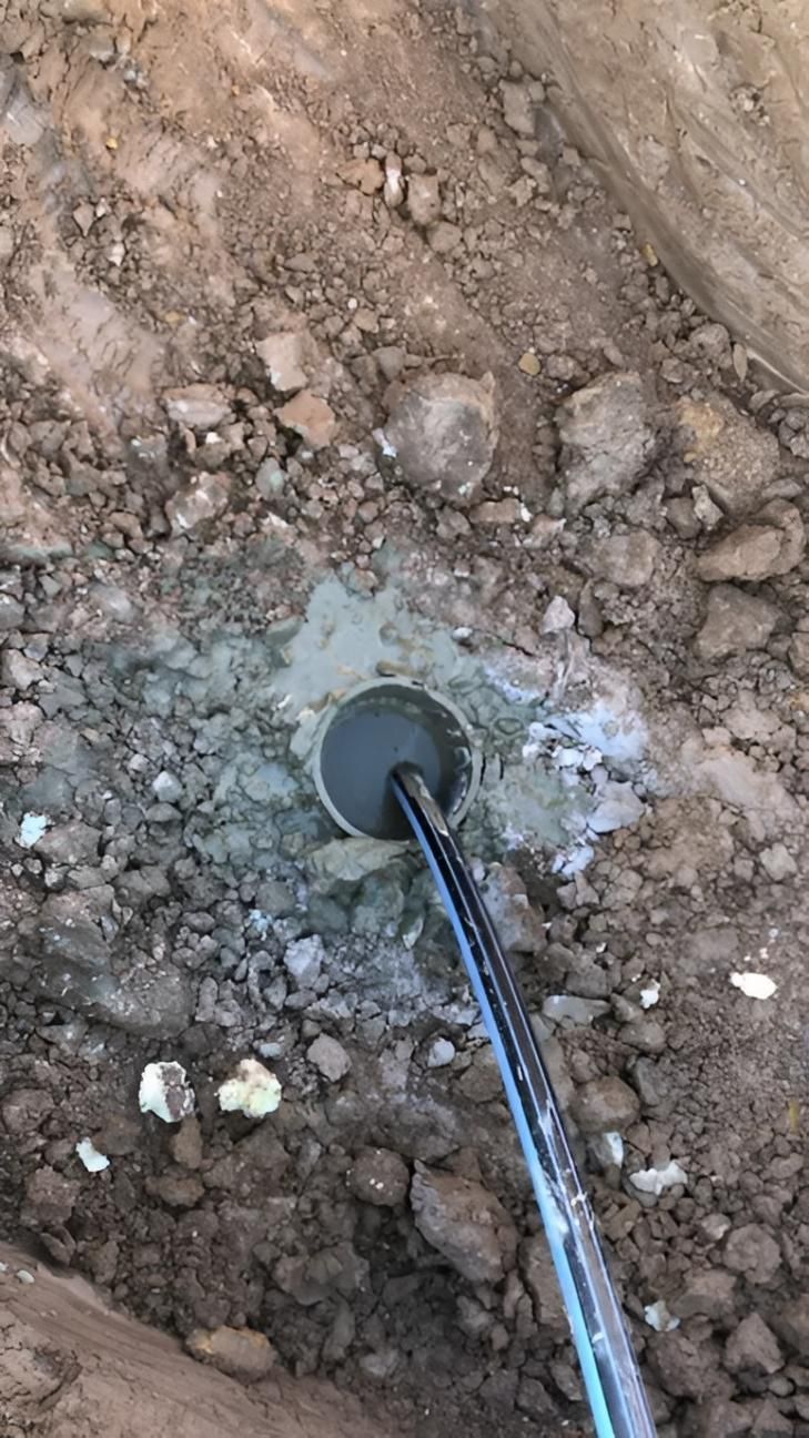 Hole in Dirt Filled With Cement and a Black and Blue Cable — Local Drilling Services In Kingaroy, QLD