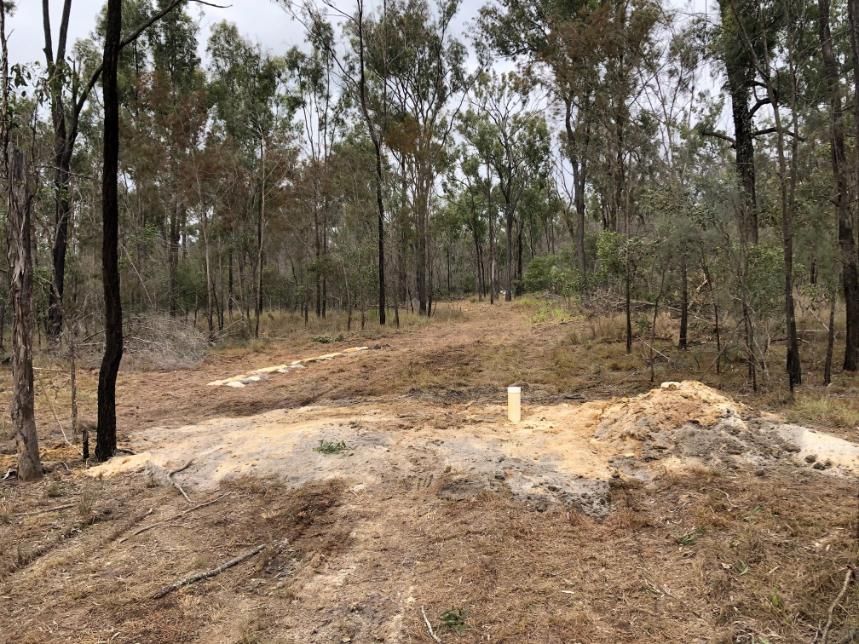 Dirt Mound in a Dry Forest Clearing With Trees, Under Overcast Skies — Local Drilling Services In South Burnett, QLD