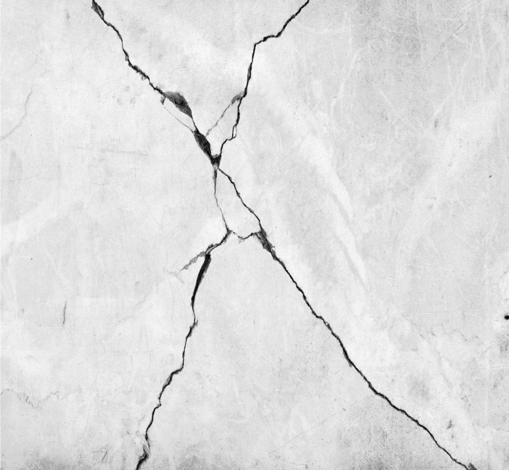 Ein Schwarzweißfoto einer rissigen Wand