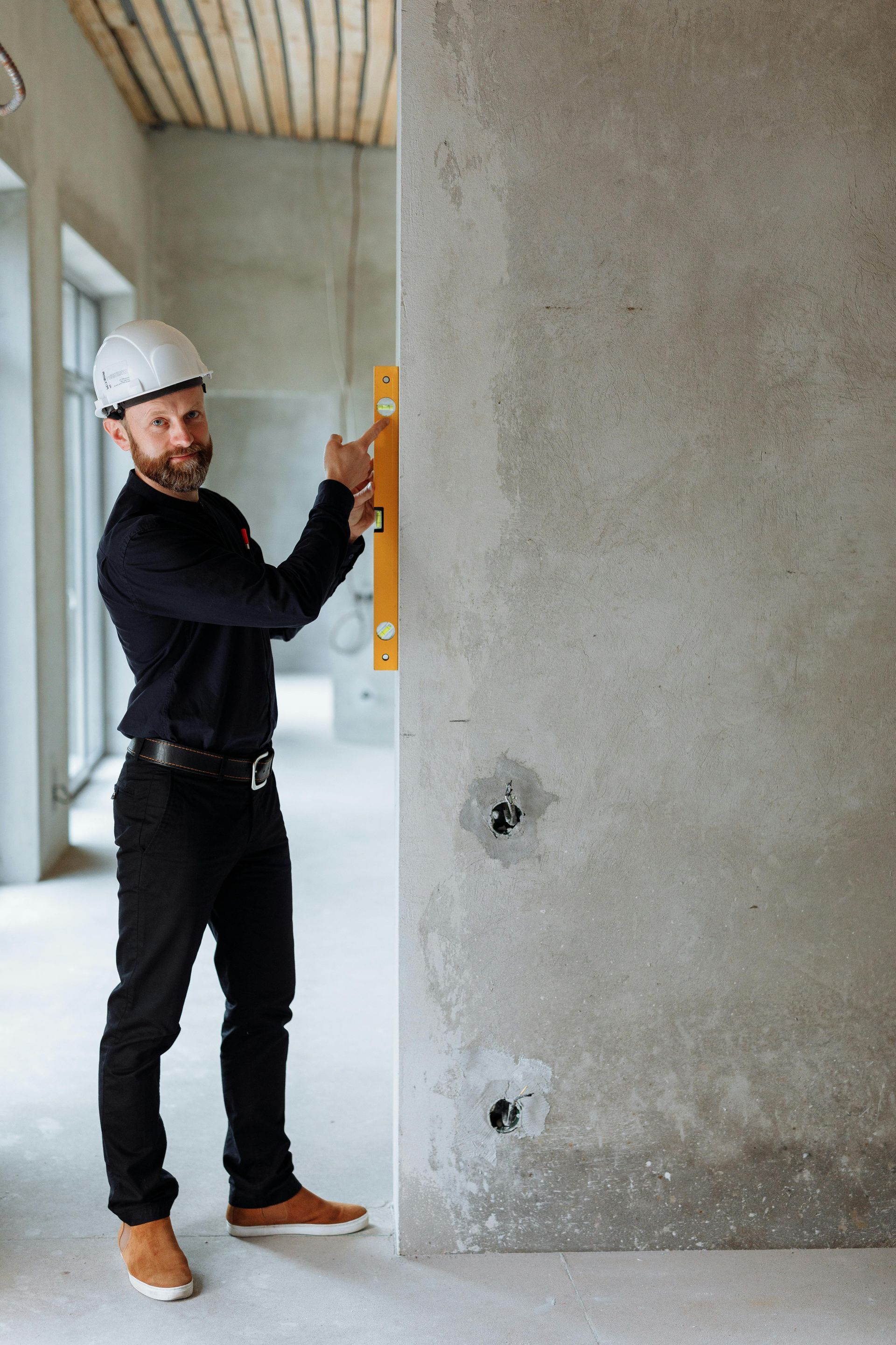 Symbolbild: Handwerker mit Wasserwaage – steht für Präzision und Qualität beim Bau