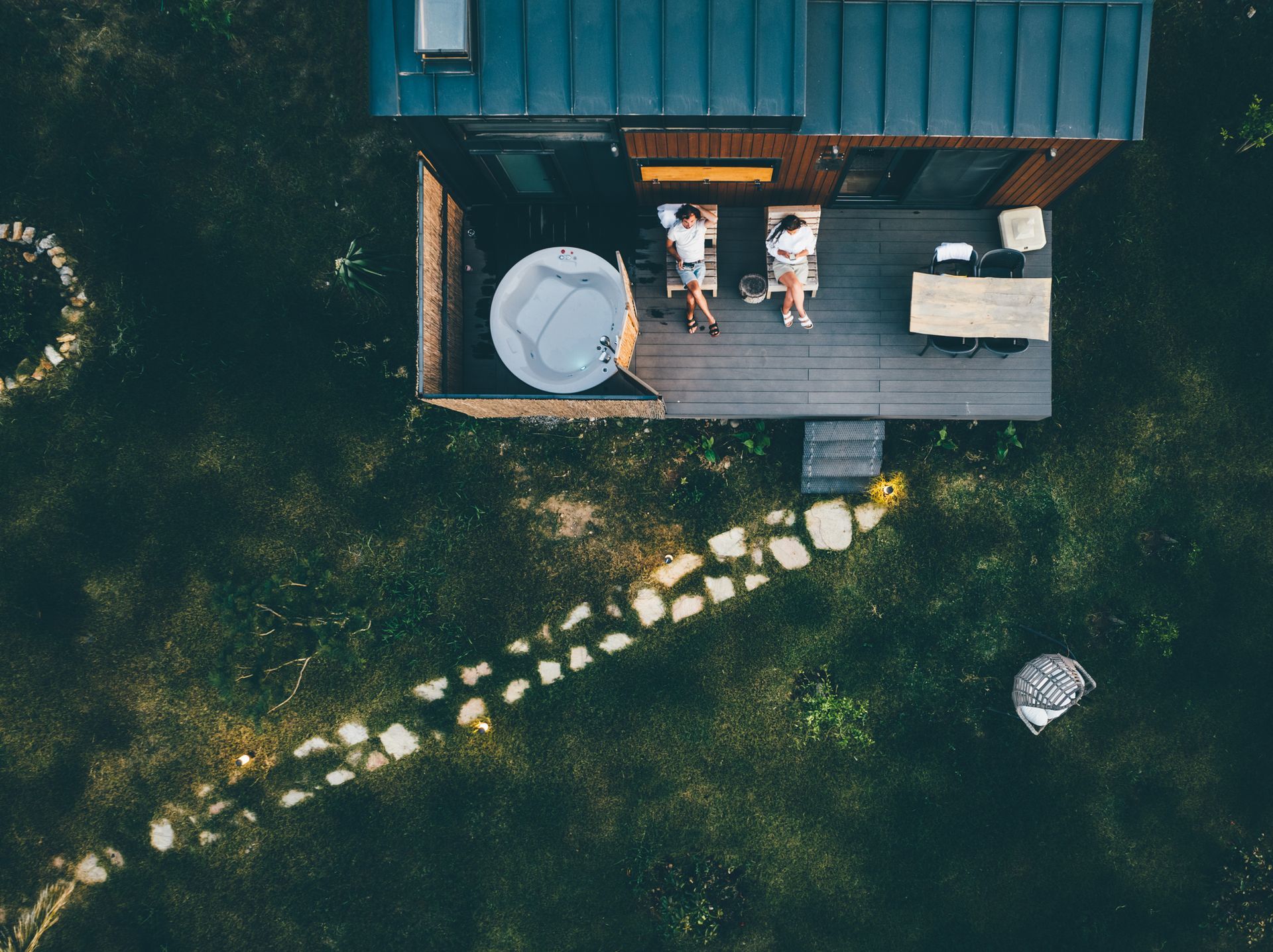 An aerial view of a house with two people sitting on the deck.