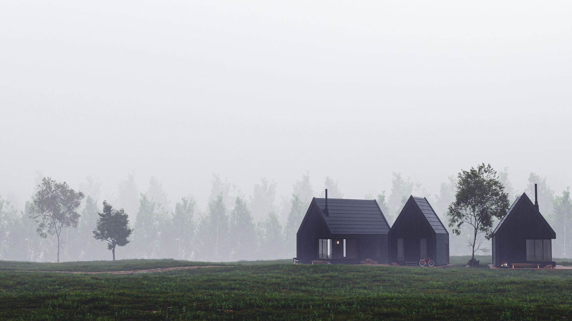 Three black houses are sitting in the middle of a field in the fog.