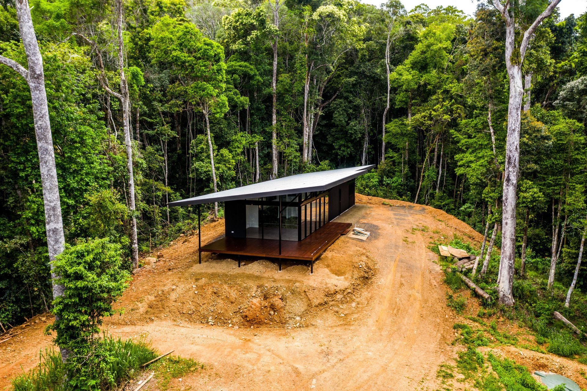 An aerial view of a house in the middle of a forest.
