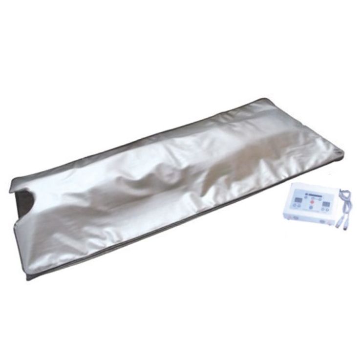 遙控器旁的白色表面上鋪著一條銀色的毯子。