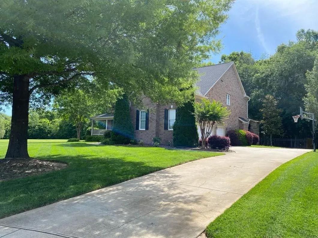 A brick house with a driveway leading to it
