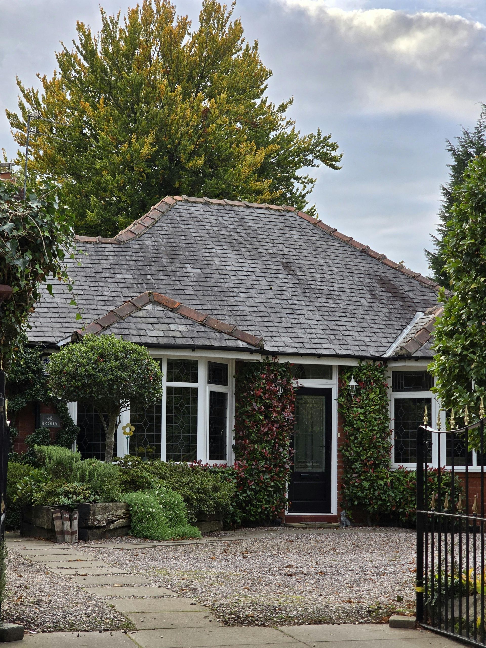 A brick house with a driveway leading to it