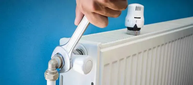 Engineer performing power flushing on a central heating system in a London home