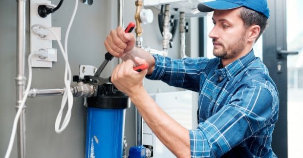 A professional plumber performing routine plumbing maintenance in a Fulham home to ensure efficient 