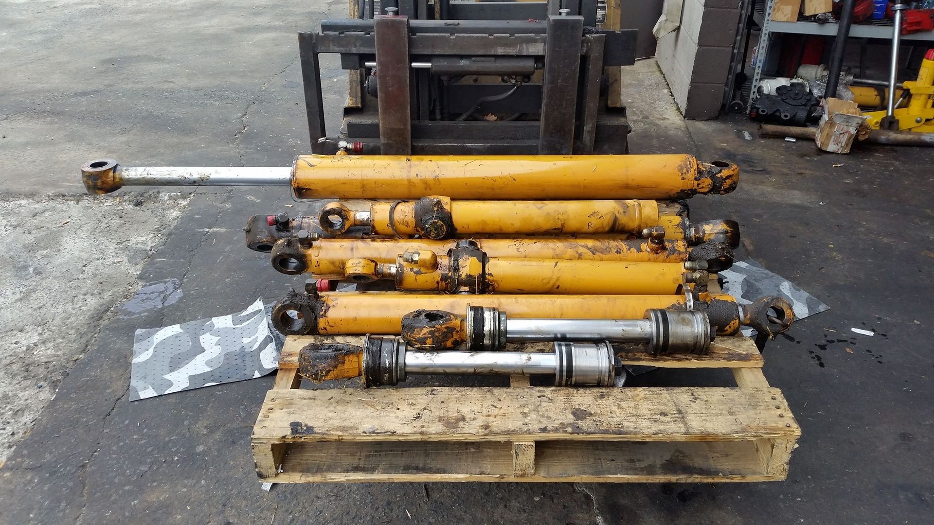 A Bunch Of Hydraulic Cylinders Are Stacked On Top Of A Wooden Pallet — Lake City, GA — A-1 Hydraulics