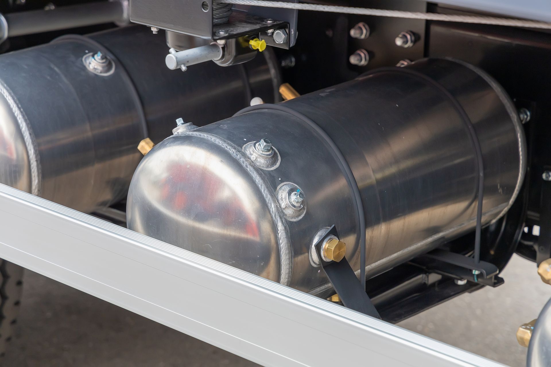 A close up of two stainless steel air tanks on a truck.