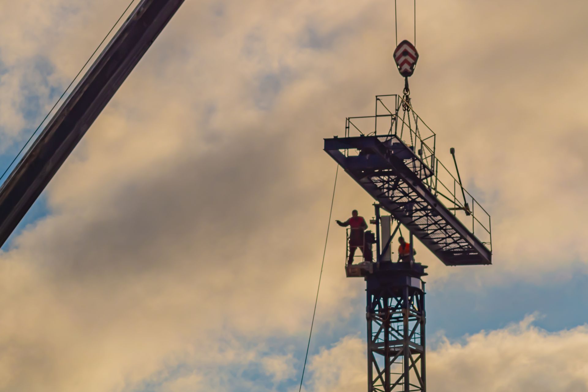 A group of construction workers are working on a crane.