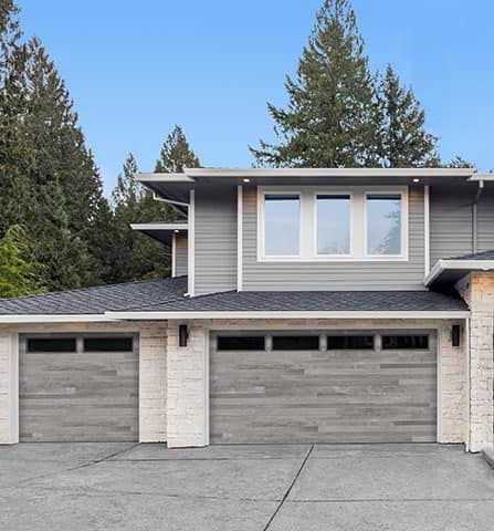 A house with two garage doors and a lot of windows