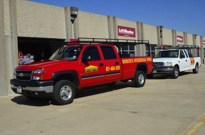 Two trucks are parked in front of a building that says liftmaster
