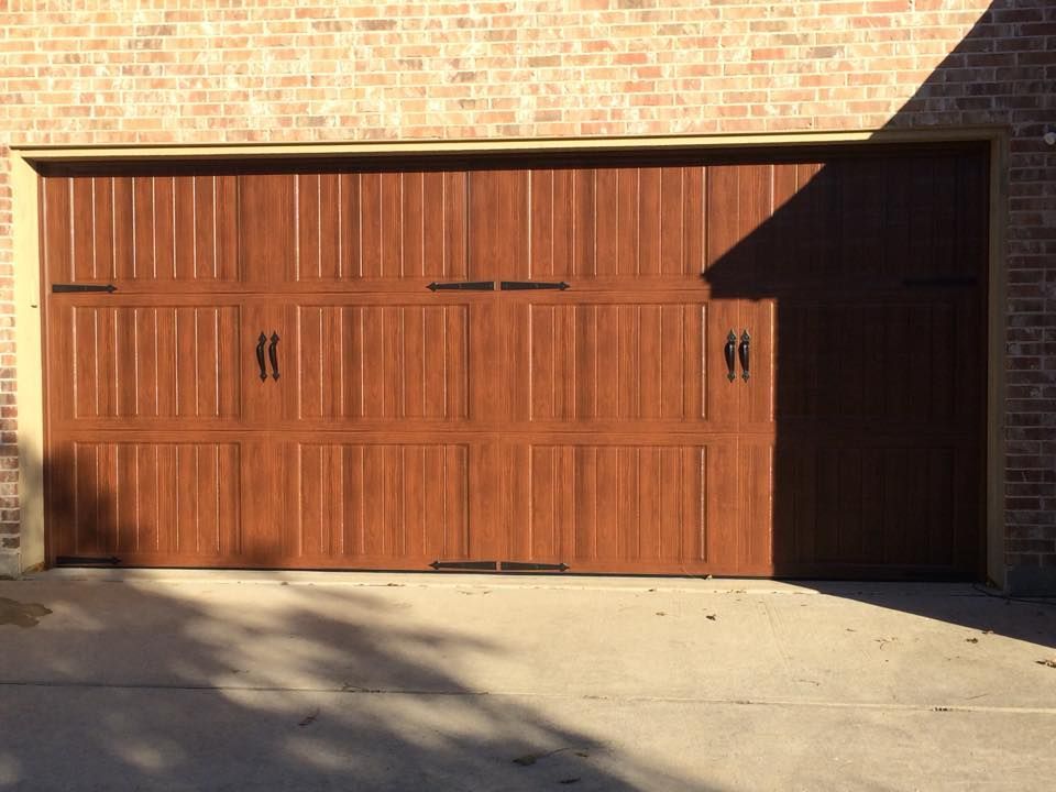 A wooden garage door on a brick building
