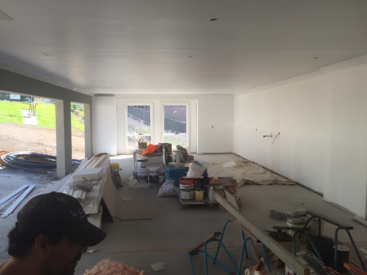 A Man in a Baseball Cap is Standing in a Room — Let's Paint & Decorate Pty Ltd in Kiama, NSW