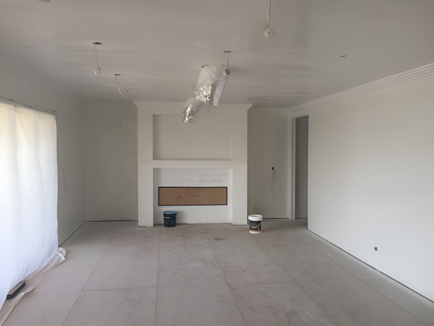 A Large Empty Room With a Fireplace in the Corner — Let's Paint & Decorate Pty Ltd in Oak Flats, NSW