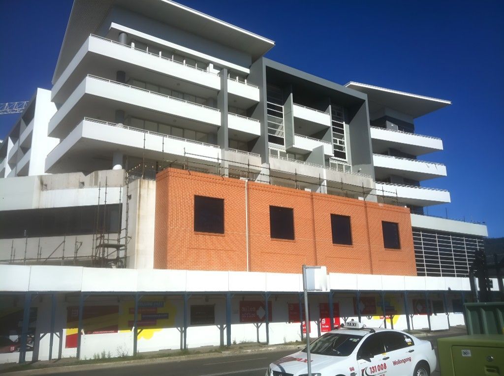 A White Car is Parked in Front of a Building — Let's Paint & Decorate Pty Ltd in Oak Flats, NSW