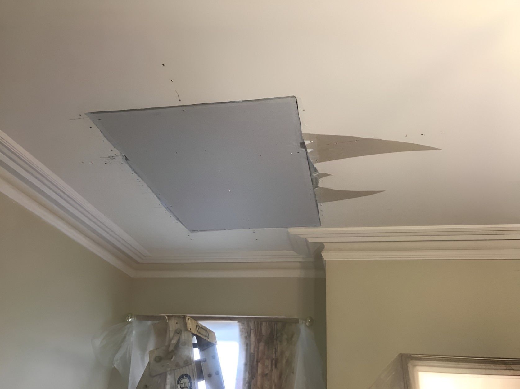 A Man is Standing on a Ladder in a Room — Let's Paint & Decorate Pty Ltd in Austinmer, NSW